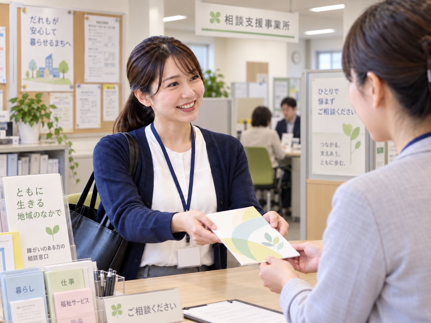 相談支援事業所の窓口で相談員にパンフレットをお渡しするTHRIVEスタッフ